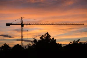 Guindaste de obra em silhueta ao pôr do sol