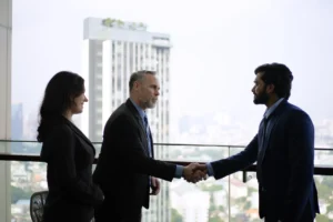 Executivos fechando negócio com aperto de mão em escritório